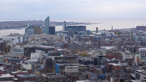 LIVERPOOL, ENGLAND, UNITED KINGDOM - NOVEMBER, 2018: High angle view of Liverpool downtown rooftops, river Mersey, Wirral and offshore wind turbines in the sea near horizon.