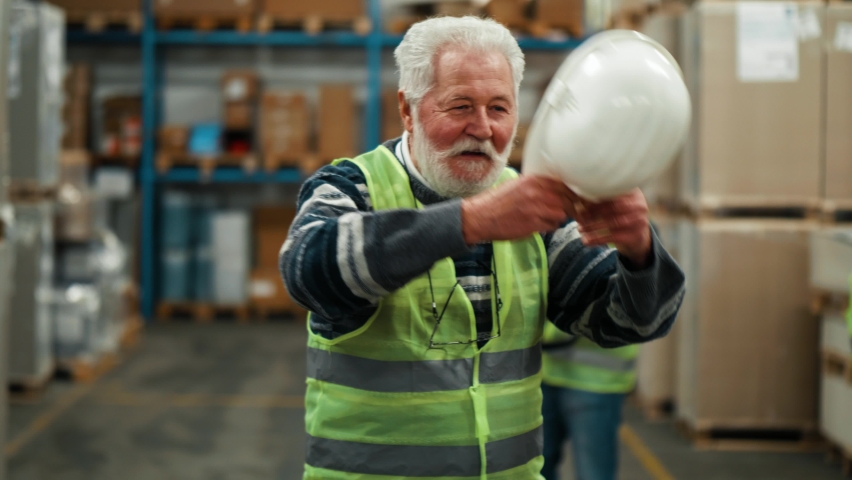 Portrait of old male warehouse worker  smiling and looking at camera