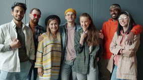 Slow motion portrait of successful business team standing indoors against gray color background smiling looking at camera. Youth and career concept. - Powered by Shutterstock - Get 15% off with code: PIKWIZARD15