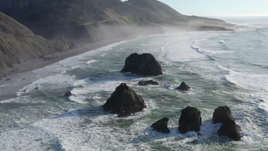 The Pacific Ocean washes onto the beautiful, rocky coastline of Northern California north of Fort Bragg. The Pacific Coast Highway runs right along this scenic region in Mendocino County. | Shutterstock HD Video #1083689227