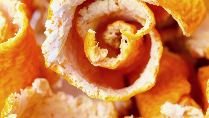 Peel of tangerine is dry close-up, twisted into spiral, rotating, macro, top view.