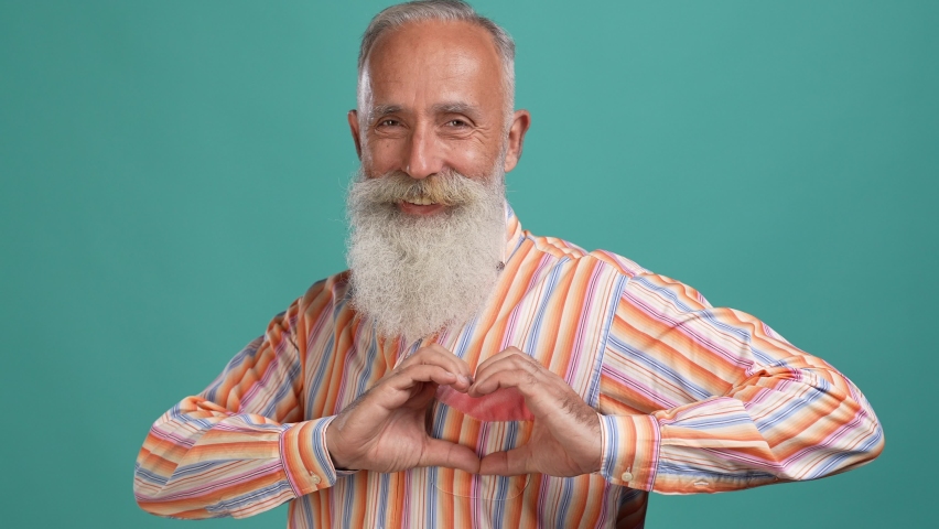 Aged man make hand heart shape romantic party isolated cyan color background Royalty-Free Stock Footage #1083696184