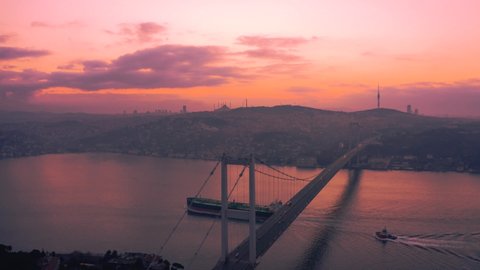 Aerial view of the ship passing under the Bosphorus Bridge at sunrise (15 July Martyrs Bridge). 4K Images in Turkey