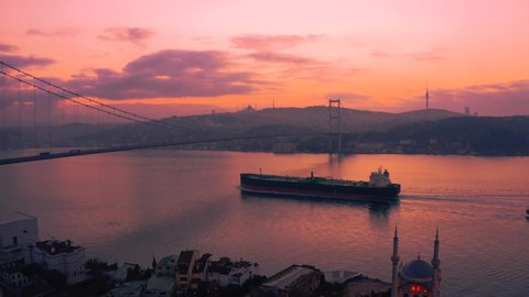 Aerial view of the ship passing under the Bosphorus Bridge at sunrise (15 July Martyrs Bridge). 4K Images in Turkey