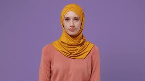 Dreamful pensive young arabian asian muslim woman in abaya hijab yellow clothes look around think dream lost in thought and conjectures isolated on plain pastel light violet background studio portrait