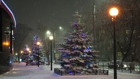 Christmas trees decorated with garlands and balloons on the street in a snowfall, pedestrians are walking on the street - Powered by Shutterstock - Get 15% off with code: PIKWIZARD15