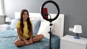 dance tutorial of cheerful teen kid blogger making video on smartphone and ring lamp at home, blog