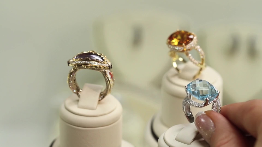 Woman hand trying on expensive jewellery rings at the jewel store, luxury jewelry close up, diamond, aquamarine, sunela Royalty-Free Stock Footage #1083712987