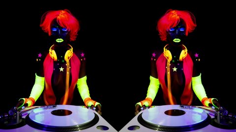 A cool sexy djing woman wearing UV fluorescent clothing and makeup and mirrored