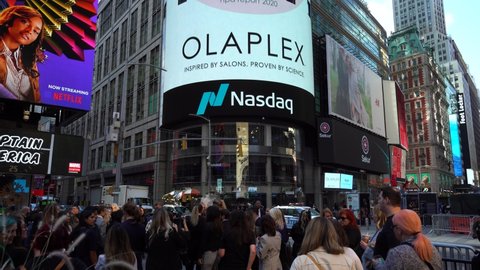 NEW YORK CITY, USA - SEPTEMBER 30, 2021: Olaplex IPO Billboard on Nasdaq MarketSite and Crowd of People at Times Square on Sunny Day.