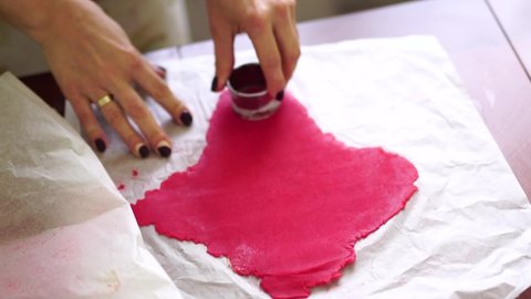 Chef cuts mold circles from the rolled red dough