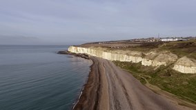 Aerial footage along Newhaven Beach heading towards the white cliffs of East Sussex.