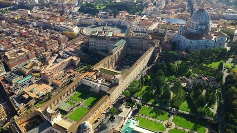 Aerial drone rotational video above iconic Vatican Apostolic Archive building, famous Saint Peter Basilica and beautiful Vatican city gardens, Rome, Italy