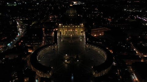 Aerial drone night video over Saint Peter's square, world's largest church - Papal Basilica of St. Peter's, Vatican - an elliptical esplanade created in the mid seventeenth century, Rome, Italy