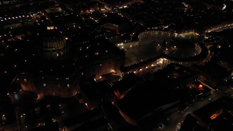 Aerial drone rotational night video of Saint Peter's square, world's largest church - Papal Basilica of St. Peter's, Vatican - an elliptical esplanade created in seventeenth century, Rome, Italy