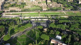 Aerial drone video of iconic Circus Maximus a green space and remains of a stone - marble arena used for chariot races built next to Palatine hill and world famous Colosseum, historic Rome, Italy