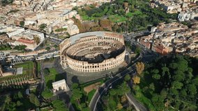 Aerial drone video of iconic park of Colosseum, a vast archaeological zone encompassing ancient sites like the Colosseum, Palatine hill and Ancient Forum, Rome historic centre, Italy