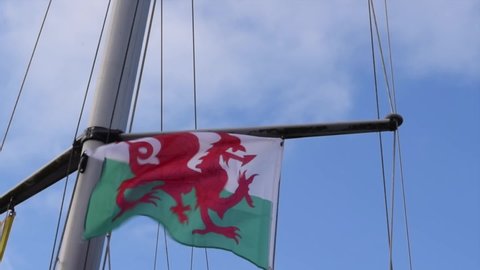 Conwy UK, December 2021:
Welsh flag is moving in wind on a boat mast.