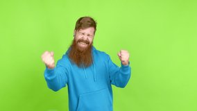 Redhead man with long beard celebrating a victory and surprised to be successful over isolated background
