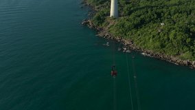 aerial drone shot of the longest cable car located in Phu Quoc island, Vietnam. Panoramic view of landscape, harbour in the bay of the ocean, sunset, golden hour, forest on the island.