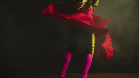 Male dancer or toreador imitating moves of matador bullfighter on black smoky background .  Man bullfighter dressed in bullfighting costume . Shot on ARRI Alexa cinema camera in Slow Motion 