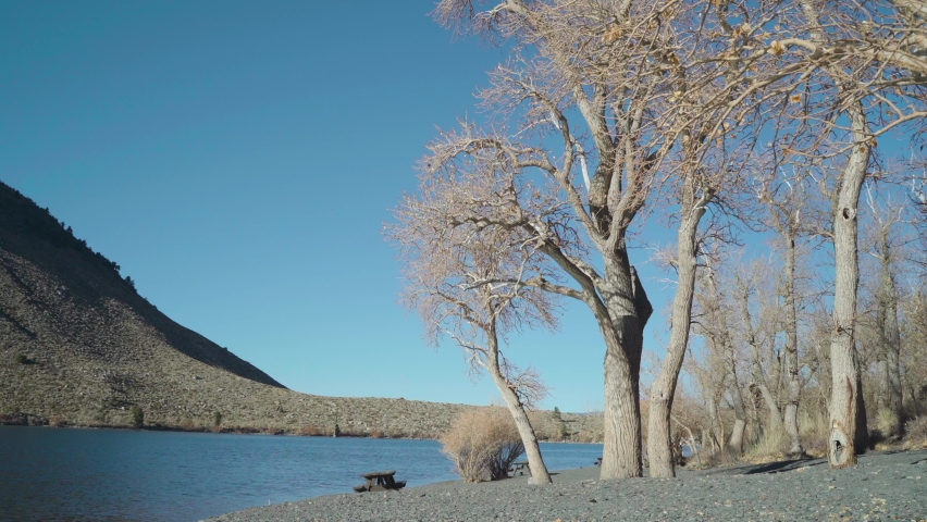 Picnic table by shore at convict lake California in fall. peaceful day with blue sky and no people. inyo national forest
