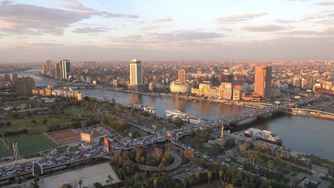 Cairo, Egypt - July 25, 2021 - panoramic aerial sunset view of the Nile and downtown Cairo with traffic and boats seen from Cairo Tower