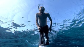 Diving to the depth. A man takes a selfie video while swimming underwater. Holiday concept