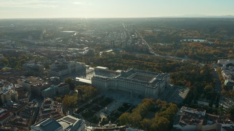 Slide and pan footage of large building on Royal Palace and Almudena Cathedral. Aerial view against sunshine.