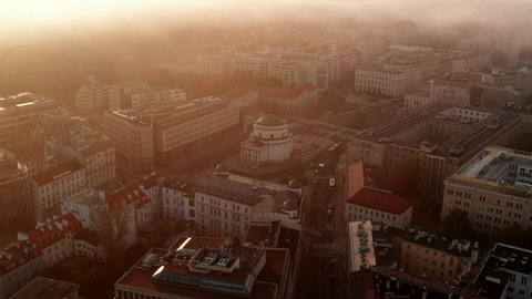 Slide and pan footage of town development. Round sacral building in town square. Misty weather at sunrise. Warsaw, Poland