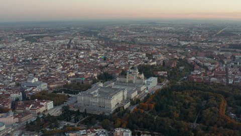 Descending footage of Royal Palace and Almudena Cathedral at dusk. Aerial panoramic footage of city with historic landmarks.
