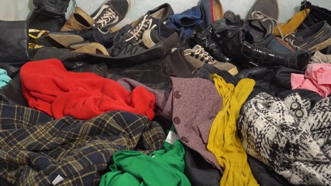 Clothes and shoes waste recycle. Pile of old used clothes. Fashion industry textile waste problem. Disposal, recycling concept, donation, charity, second hand
