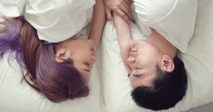 Loving young Asian couple spending a morning in bed at home.