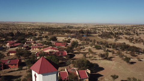 4K aerial drone video of Africa savanna hills and plains, tiny settlement Baumgartsbrunn and small white stone church west of Windhoek in central highland Khomas Hochland of Namibia, southern Africa
