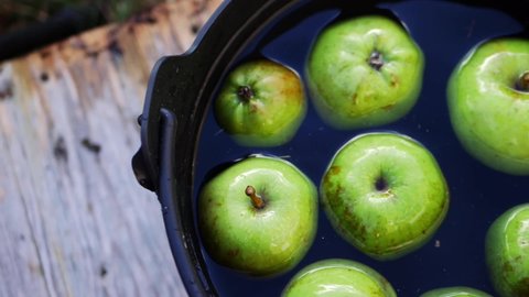 Fresh Apples in a cauldron for bobbing at Halloween flat lay slow motion slider shot selective focus 