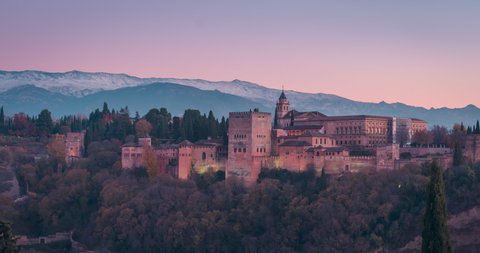 Alhambra and Snowy Sierra Nevada day to night time lapse in Granada, Andalusia, Spain.