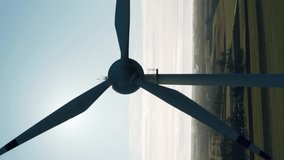 Vertical video aerial drone view windmills wind turbines producing clean ecological electricity on sunny autumn day. Wind farm generating alternative green renewable energy
