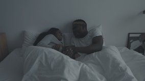 Lovely couple traditions. Young loving african american man and woman lying in bed and talking to each other, discussing last day together before sleep, tracking shot, slow motion - Powered by Shutterstock - Get 15% off with code: PIKWIZARD15