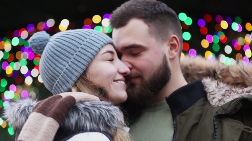 Beautiful couple, boyfriend and girlfriend are kissing on Christmas fair in Wroclaw, Poland