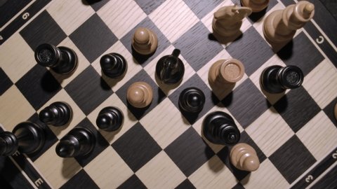 rotating chessboard with combination of white and black wooden chess figures . Top view. High quality 4k footage