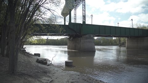 Slow moving muddy water under a bridge in downtown Winnipeg