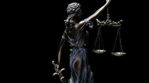 The statue of Lady Justice rotating on a black background. Law theme with Roman goddess of justice