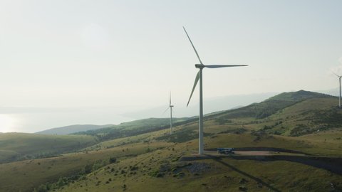 Aerial footage of wind turbines in the mountains on the background of island Krk in Croatia. Generation of green electrical power, October 2021, Vratarusa, Croatia.