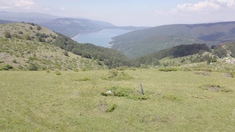 Horizontal drone fly showing the Mavrovo sign with the lake in the background, Macedonia