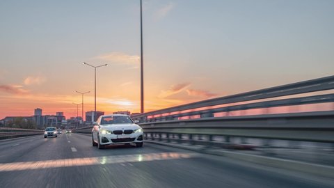 Berlin, Germany-10.10.2021: Rolling shot of a BMW 3 series, luxury sport sedan car driving on highway at sunset, cinematic close up view