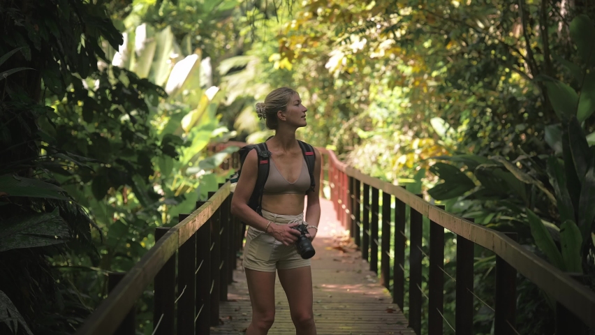 Female traveler photographer taking photo's of beautiful Cahuita natural rainforest on boardwalk Royalty-Free Stock Footage #1083833662