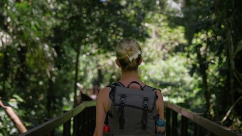 Behind female backpacker walking through wonderful lush jungle of Cahuita National park
