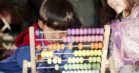Front view, The children are playing with the colorful abacus. In the morning at home with the soft sunlight.