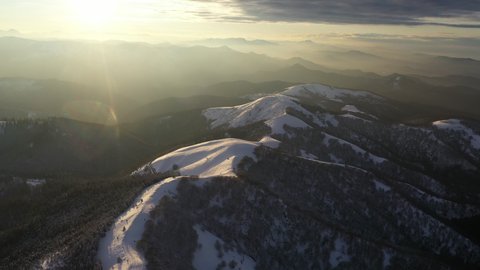 Aerial view of snowy mountain during sunset