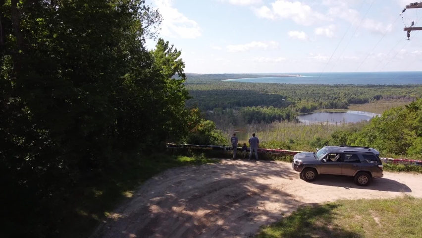 People Admiring Forested Landscape Of Sleeping Bear Dunes National Lakeshore And Glen Lake Along The Coastline Of Lake Michigan Near Glen Arbor. wide aerial